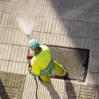 worker-cleaning-a-street-sidewalk-with-high-pressu-2021-08-31-23-10-23-utc